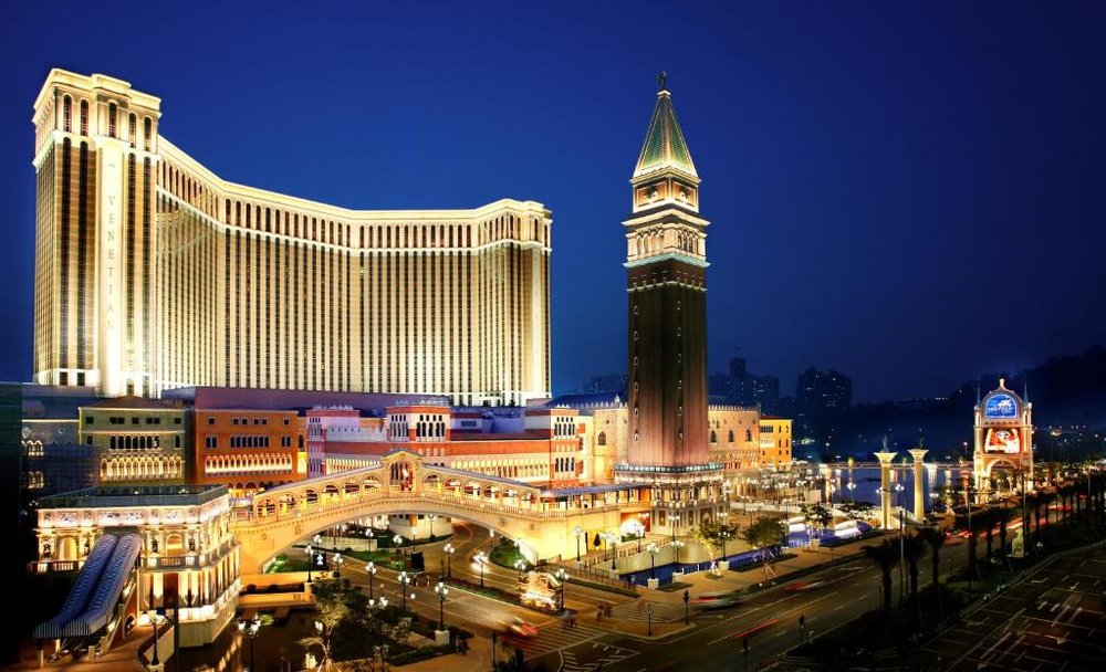 Torre del Venetian y el campanile iluminados de noche, con el canal y el puente al frente